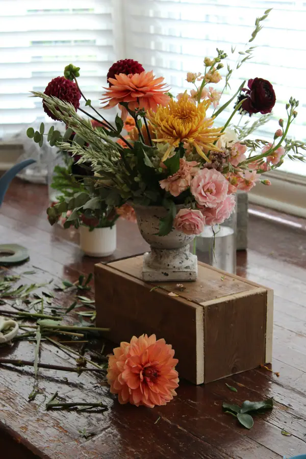 Autumn arrangement of dahlias and roses on a rustic wooden table