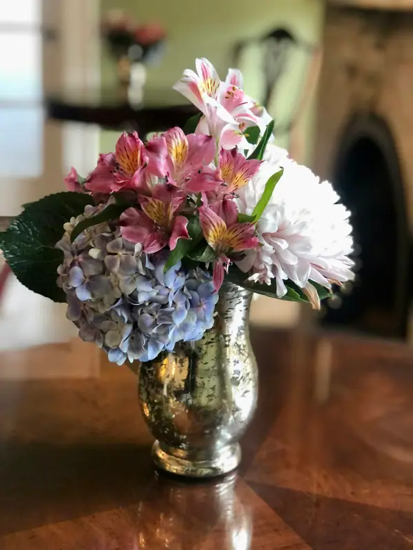 Lilies, hydrangea and chrysanthemums in a mercury-glass vase