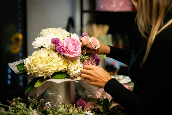 Florist arranging hydrangeas and roses