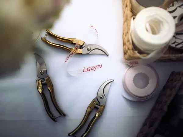 Floristry shears and ribbon on a white table
