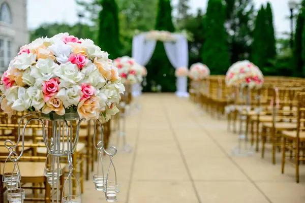 Aisle lined with white and pink floral arrangements