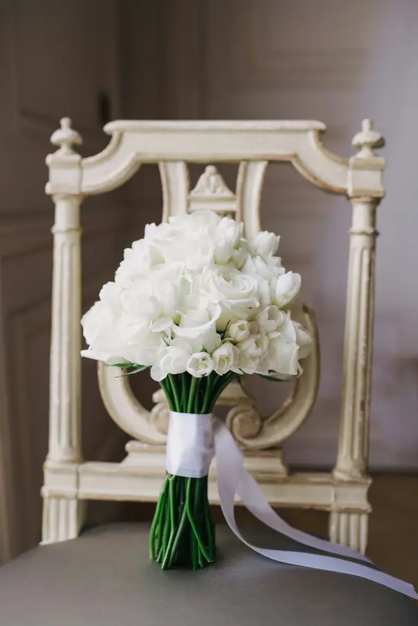 White bouquet resting on an ornate chair