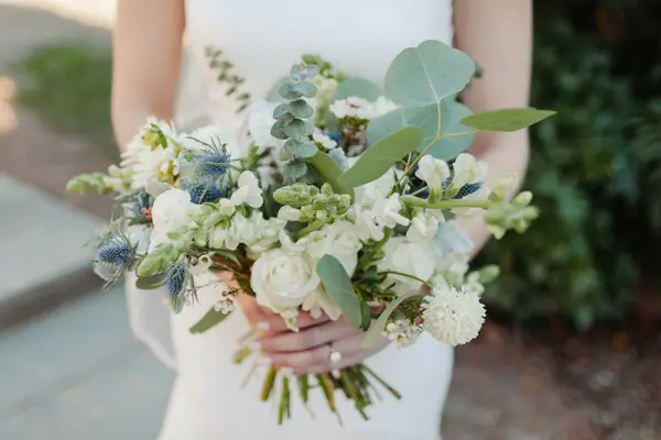 Bride holding a white and green bouquet with eucalyptus