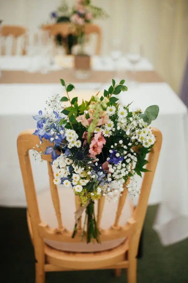 Small white posy tied to a wooden chair