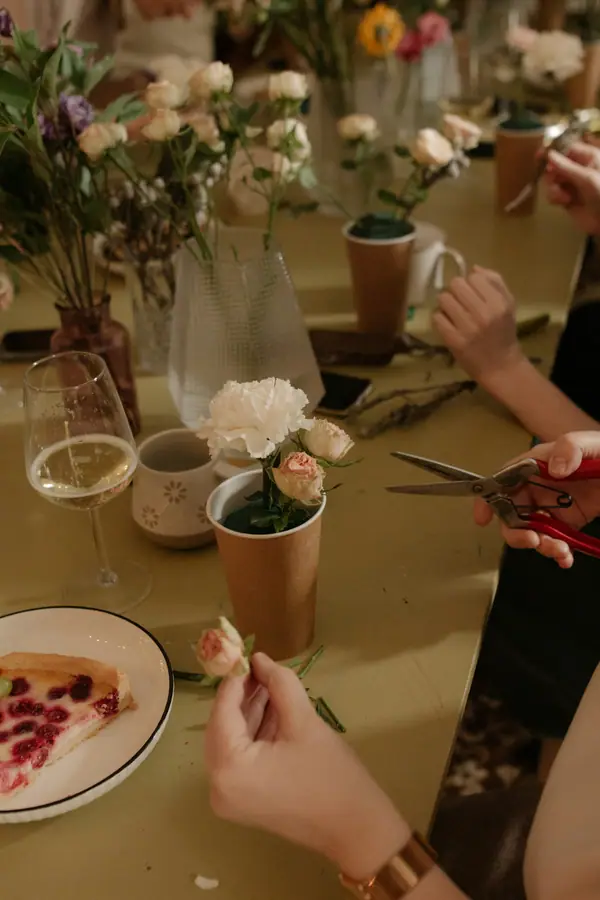 People arranging flowers together around a table